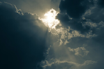 The rays of the sun shine through the cloud overcast in the evening before sunset.