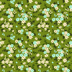 Floral pattern. Pretty flowers on green background. Printing with small white and light blue flowers. Ditsy print. Seamless vector texture. Spring bouquet.