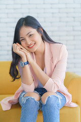 Asian woman smile relaxing sitting on sofa at living room, Lifestyle relax concept.