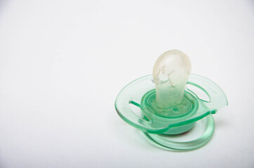 Nipple for children green. The child gnawed, tore the dummy. A hole in the dummy. Latex silicone on a white background