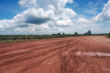 Pools of rainwater on a dirt road in the east kalimantan/indonesia countryside. Country road after...