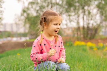 little girl enjoys the first spring flowers on a walk
