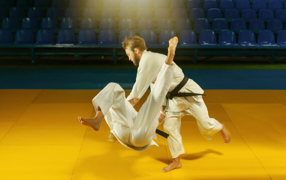 Martial Arts. Sparing Portners. Sport Man And Woman In White Kimono Train Judo Throws And Captures In The Sports Hall