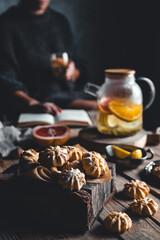 Woman is reading and Hot tea with fresh grapefruit on wooden tablet. Healthy drink, Eco, vegan.