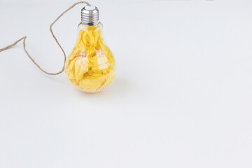 yellow paper in a transparent light bulb - concept idea