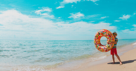 happy cute boy with floatie at tropical beach