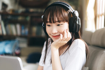 Asian teenager woman listen music with headphone stay at home.