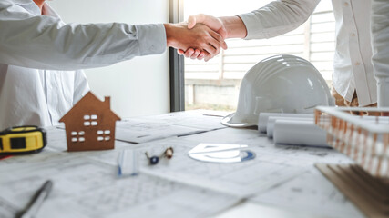 Team Engineer colleagues shaking hands and meeting for architectural project on workplace