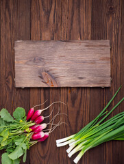 Ingredients for a salad of greens and radishes on a dark wooden background. Healthy food, veganism, vegetarianism.