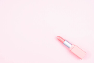 Pink lipstick isolated on pink background with copy space