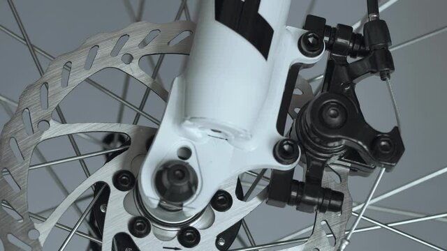 Brake system of a caliper and a metal brake disc on a bicycle, background, macro