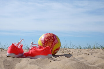 red shoes and volleyball on a beach background healthy life concept