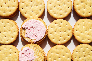 Sandwich cookies with pink strawberry cream filling on white background. Trendy minimal food. Simple bakery, top view