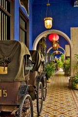 old rickshaw, palm tree and chinese lantern in The Blue Mansion in George Town, Penang,  Malaysia