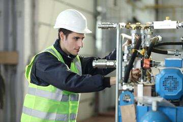 Portrait of a man , factory engineer in work clothes controlling the work process at the airplane...