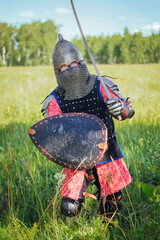 A medieval Central Asian warrior, a nomad in 14th-century armor, stands in a defensive or attacking...