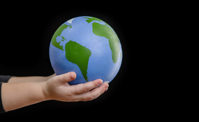 Close up little girl holds planet in her hands. Ecology concept. Empty space for text