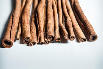 closeup big heap of dry cinnamon sticks served on white table surface