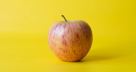 Fresh red yellow apple fruct isolated on yellow background.