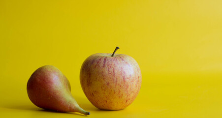 Pear and apple. Fresh red yellow fructs isolated on yellow background.