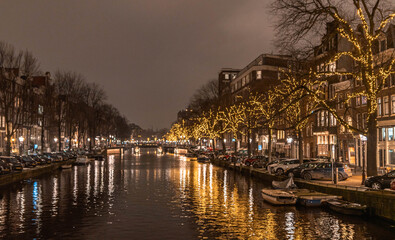 Amsterdam, traditional buildings and river at night