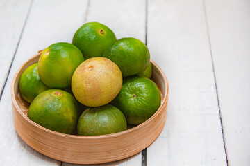 Lemon in basket on white wood.