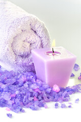 Obraz na płótnie Canvas Vertical composition of spa treatment: Candles and Towel with purple sea salt