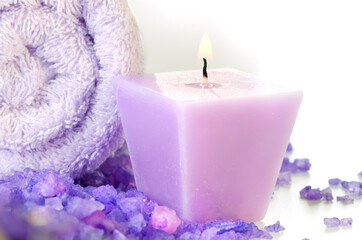 Fototapeta na wymiar Composition of spa treatment: Candles and Towel with purple sea salt