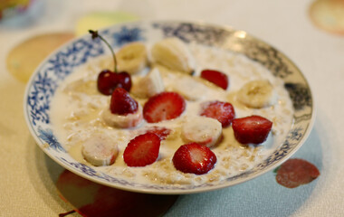 healthy breakfast - porridge with fruit strawberry, banana and cherry