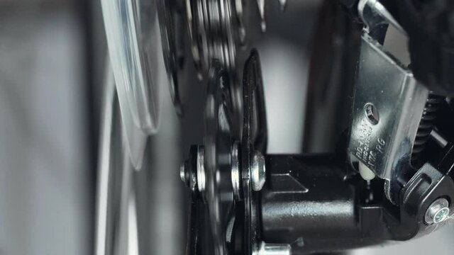 Gearshift on mountain bike MTB, chain moves on cassette, rear derailleur. Changing speeds, jockey wheel, upper pulley. Shift gears on cogset cogs. Work of bicycle chain drive. Macro closeup shot