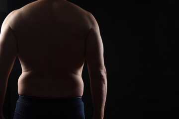 body of a real man man on black background, rear view