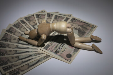 お金と落ち込むデッサン人形