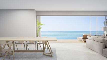 Empty table of bright dining room near living room and sofa in modern beach house or luxury pool villa. White home interior 3d rendering with sea view.