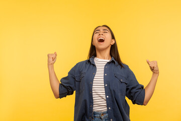 I'm champion! Portrait of thrilled enthusiastic girl in denim shirt shouting joyfully, extremely...