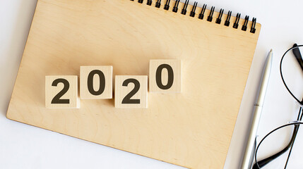 Abstract 2020 New year countdown design concept - wood blocks cubes on wooden NOTEBOOK