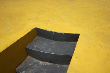 Public stair with yellow concrete floor.          