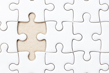 Closed up background of white plain jigsaw wait missing piece to match or fulfill - obrazy, fototapety, plakaty