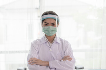 Fototapeta na wymiar Young Asian female doctor wearing face shield for coronavirus or Covid-19 protection