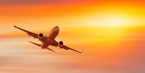White passenger airplane in the clouds at sunset  - Travel by air transport