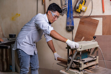 Asian carpenter man stay home work and repair wood craft DIY ,portrait of happy attractive hardwork professional worker.