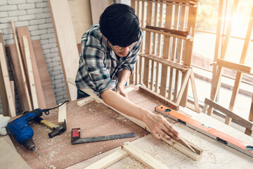 Carpenter Man is Working Timber Woodworking in Carpentry Shop, DIY Craftsman is Measuring Tape Furniture Wood in Workshop. Male Carpenter DIY Craft Work is Concentrated His Job, Labor Skill Builder