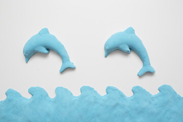 Kinetic sand - modern toy for children development. Form dolphin and blue water.