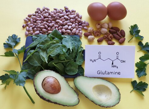 Food rich in glutamine with structural chemical formula of glutamine molecule. Food for training and exercise: spinach, eggs, parsley, avocado, beans, almond, walnut. Bodybuilding, sport nutrition.