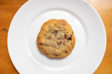 Simple Chocolate Chip Cookie on a White Plate on a Wood Table