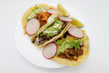 Three Tacos with Limes on a White Plate with a White Background