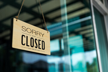Label 'Sorry we are closed please come back again' notice sign wood board hanging on door front...