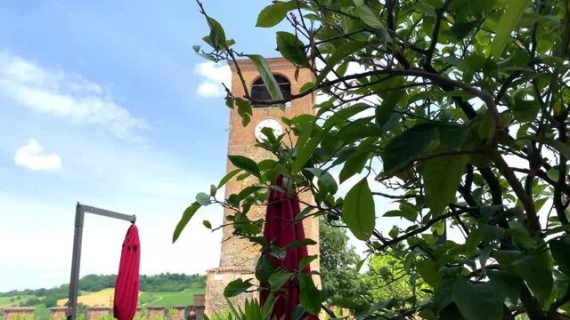 Ancient clock tower behind a lemon tree