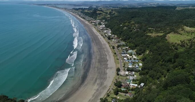 4k aerial forward with slight tilt down motion above the popular tourist beach of Ohope Beach, known as one of the top beaches on the North Island of New zealand