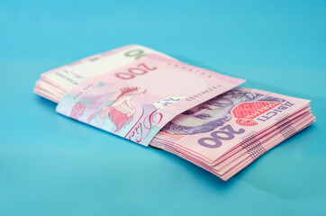Fototapeta premium UAH. Money of Ukraine 200 hryvnia, Ukrainian banknotes isolated on blue background
