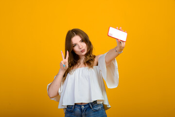 Excited woman with digital device. Studio shot of shocked girl holding smartphone, emotional